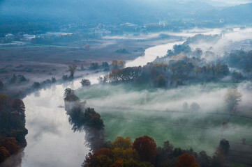 autumnal foggy morning sunrises over the Adda river, Lecco, Italy	
