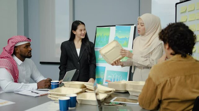 Group of multicultural business people in a discussion reusable product, implementing environmental protection, using whiteboards and presentation materials, eco-friendly packaging