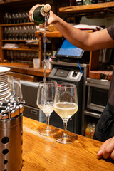 Pouring of txakoli or chacolí slightly sparkling very dry white wine produced in Spanish Basque Country in typical pinchos bar in old part of San Sebastian or Donostia, Spain