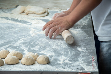 Making of flat pita bread on street market
