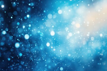 Fototapeta premium A shimmering blue background filled with soft, glowing bokeh lights, creating a dreamy and ethereal atmosphere.