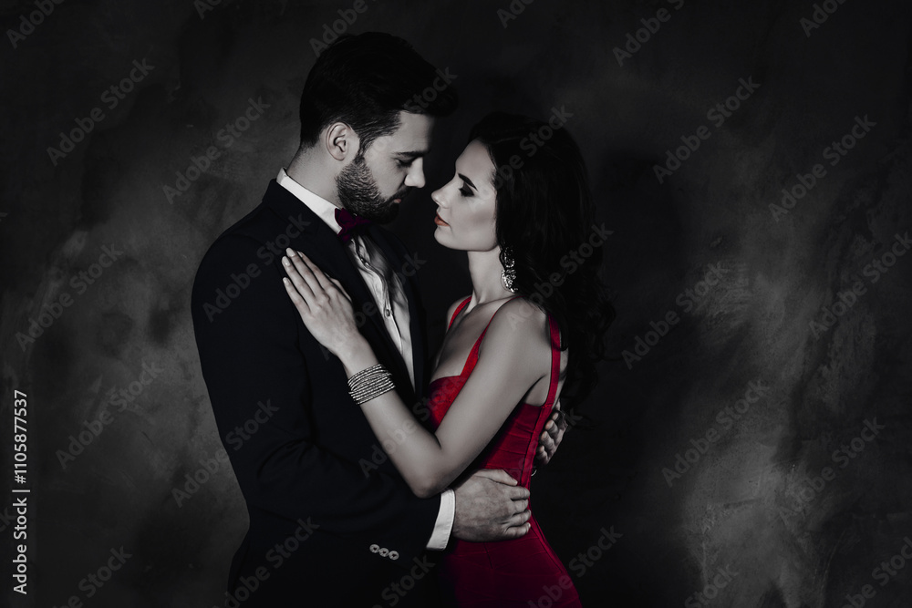Poster side view portrait of attractive lovely couple, virile harsh gentleman in tuxedo embracing his prett
