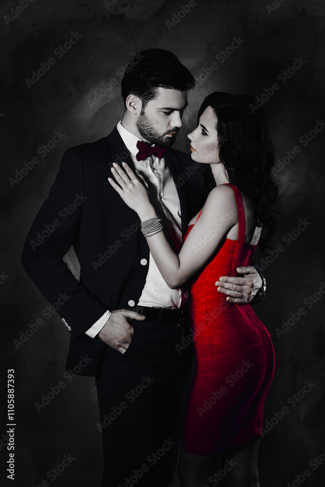 Poster portrait of bearded man in tuxedo with bow holding hand in pocket of pants and charming pretty lady 