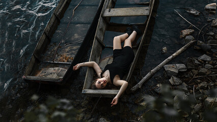 A girl by the river in a black dress, blue water all around and a fabulous atmosphere