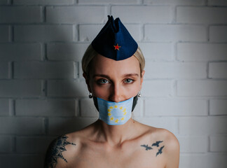 Portrait of a woman wearing a Yugoslavian pioneer hat and European flag face mask