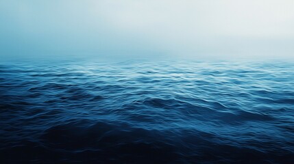 Obraz premium Deep blue ocean waves rolling under a foggy sky create a moody and atmospheric seascape, evoking a sense of mystery and tranquility