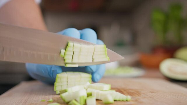 Chef Cuts Zucchini Vegetable On A Wooden Cutting Board In Restaurant Kitchen