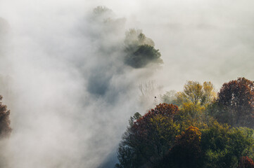 autumnal foggy morning sunrises over the Adda river, Lecco, Italy 