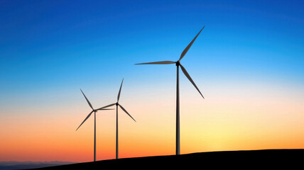 Obraz premium Wind turbines on serene hilltop glowing under vibrant sunset sky create peaceful landscape. silhouettes contrast beautifully against colorful horizon