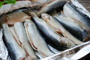 Raw fish before cooking in the kitchen. Preparing trout for baking in a roasting pan. Cooking in the home kitchen, fish for holidays, fish dishes.