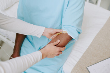 Medical professional assisting patient with intravenous therapy in hospital bed, ensuring comfort and care
