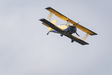 A yellow biplane in the sky. Close up view. © Skatty