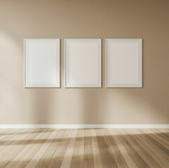 Spacious beige room with three white framed wall arts and wooden flooring.