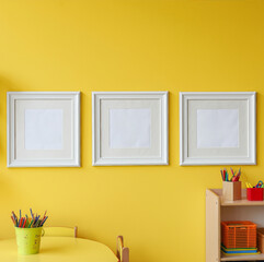Vibrant Yellow Children's Art Space with Triple Frames and Creative Supplies