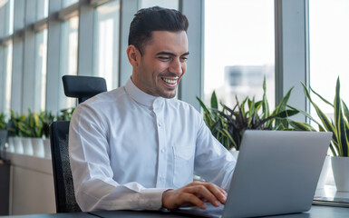 Fototapeta premium Middle Eastern male manager working on a laptop computer in a modern office.