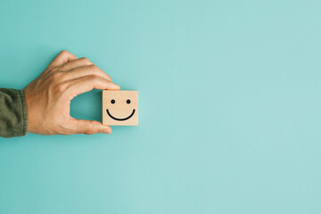 Obraz premium Service rating, satisfaction and positive feedback concept. Customer show smile face emoticon for rating indicates the highest level of satisfaction with the service