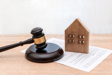 Wooden House Model with Judge's Gavel and Legal Document on Table, real estate law or property contract