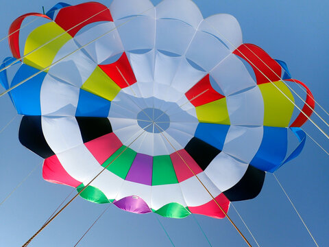 Detail of a colourful parasail parachute against the blue sky