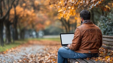 A person working on a laptop in a serene autumn park setting.