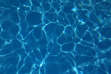 background of blue and light blue tones of swimming pool water with light reflections without people