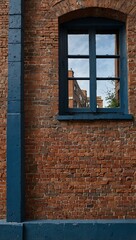 Exploring a historic blue brick wall window in an urban setting.