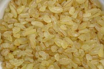 Heap of raw bulgur close up. Bulgur texture macro.