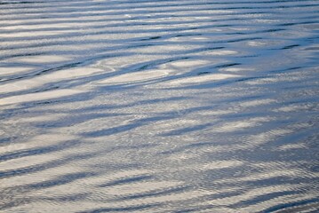 Ripples on the surface of the water of a large lake at sunset.                               