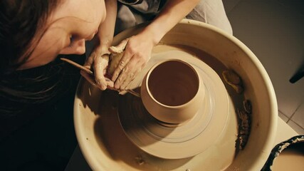 Woman potter works with clay on master class in studio. Working process in ceramic workshop. Potter making vase on pottery wheel. Handmade concept. 