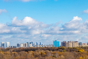 blue sky with low clouds over city park in autumn