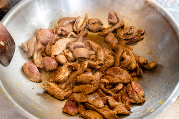 cut into pieces turkey fillet is fried in wok