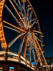 Ferris wheel at night with bright lights.