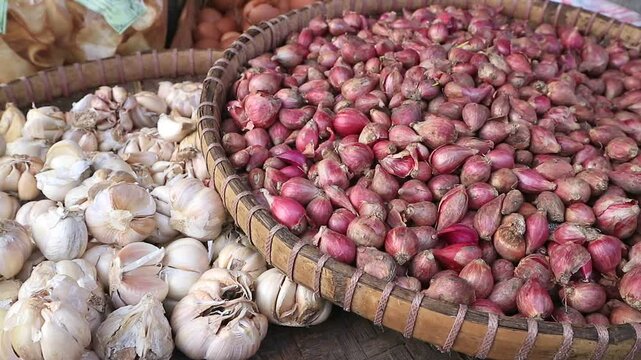 Pile of fresh garlic and red onions at traditional market Indonesia, for sale. Retail market