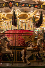 illuminated carousel with vintage horses at night, festive decorations, traditional merry-go-round,...