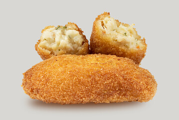Crispy handmade chicken croquettes, halved and placed on a surface with a white background, close-up view