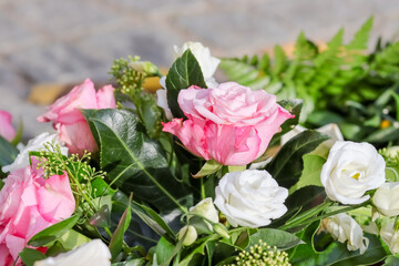 Pink and white flower arrangement. Beautiful grave flowers on a grave in a cemetery. A beautiful bouquet of flowers comforts grieving relatives. Relatives want to remember the deceased with flowers.