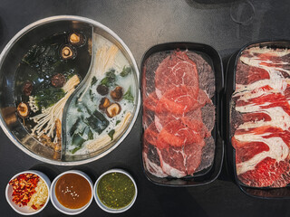 Set of Asian Shabu Buffet with sliced beef, two soup and three sauces.