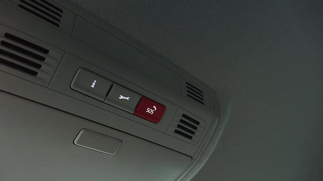 Valmiera, Latvia - November 28, 2024 - Close-up of a car ceiling control panel featuring an SOS emergency button, a service button, and air vents, highlighting functionality and design.
