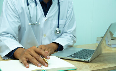 computer notebook and medical text book at desk in the hospital. Medical concept