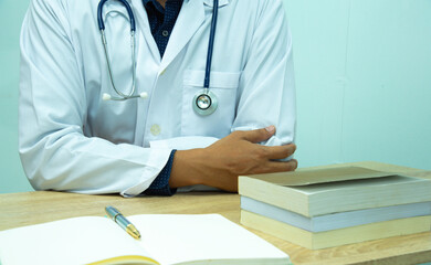 Doctor is documenting a patient's information. The physician, in the white medical coat is filling out a medical record form during a consultation in the clinic.