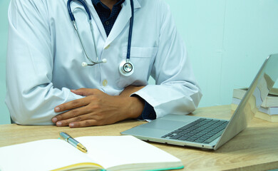 computer notebook and medical text book at desk in the hospital. Medical concept