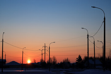 Horizontal landscape photography with a receding perspective of street lamp posts off at dusk....