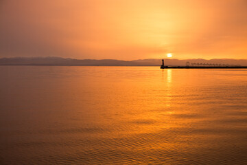 Fototapeta premium Sunset Over Calm Water with Pier in Distance 