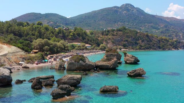 Aerial drone video Porto Zorro beach on Zakynthos island Ionian sea coast in Greece. Famous rocks in sandy beach. People swimming in clear water