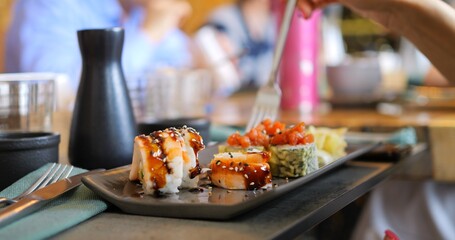 Modern dining with Japanese cuisine. Elegant setting with sushi rolls, Japanese cuisine's blend of flavor and style. Vibrant dishes create the perfect scene for food lovers in chic restaurant.