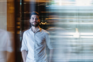 Confident young man standing in modern bright interior space