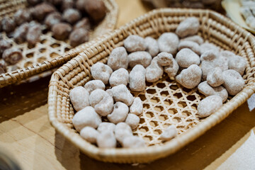 On a beautiful wooden table, there rests a delightful basket filled entirely with a variety of nuts, showcasing natures bounty and inviting exploration of its rich flavors and textures