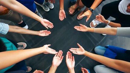 A group of people with different skin tones join their hands together in a circle, symbolizing unity, cooperation, and support