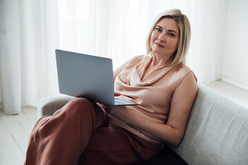 woman with laptop working on sofa