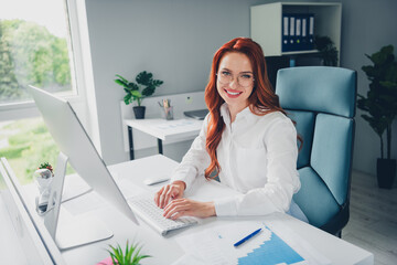 Photo of attractive young woman sit table working computer wear formalwear modern office room...