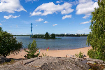 Hietaniemi sand beach in central Helsinki, Finland, sunny summer day, power lines in background
